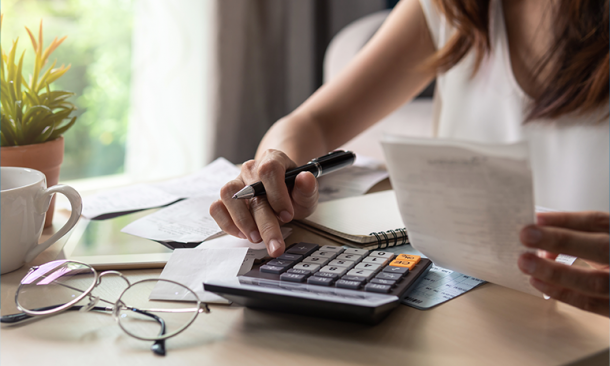 Person reviewing receipts and forms while using a calculator