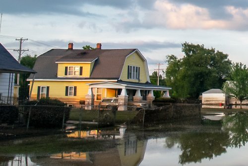 Yellow suburban house on flooded street