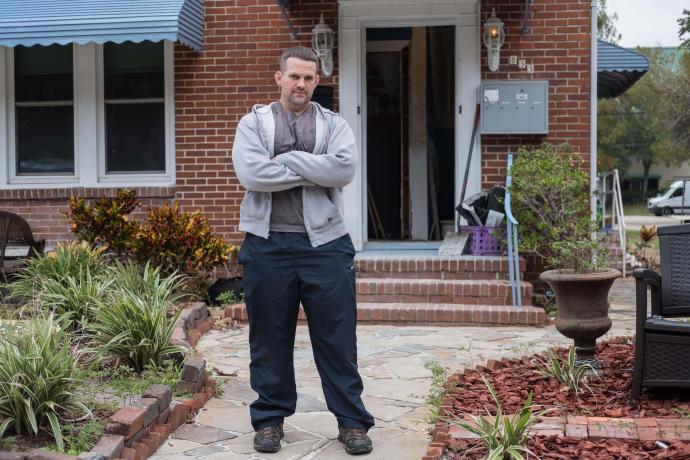 Image depicting a man standing outside a home