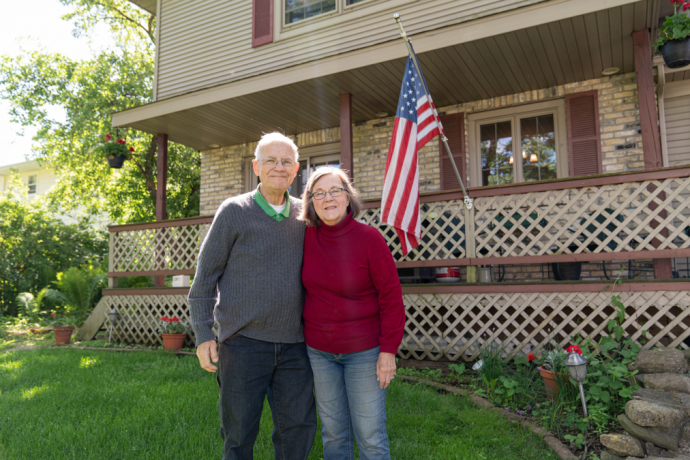 An image of a couple standing outside of a house
