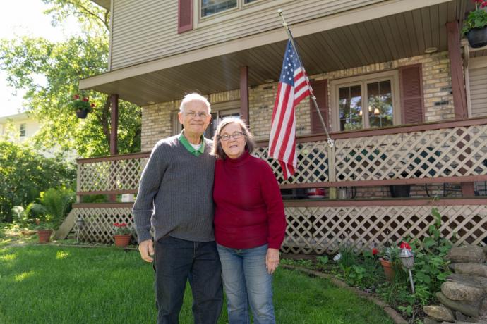 An image of a couple standing in front of a house.