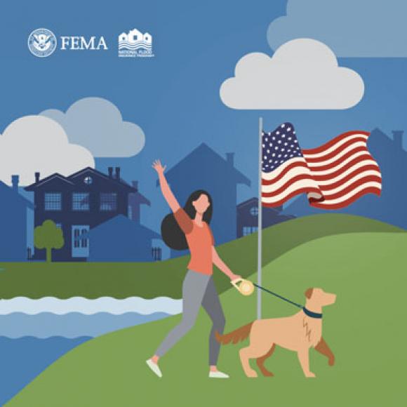 Woman walking her dog past an American flag, next to a lake, with city homes silhouetted in the background