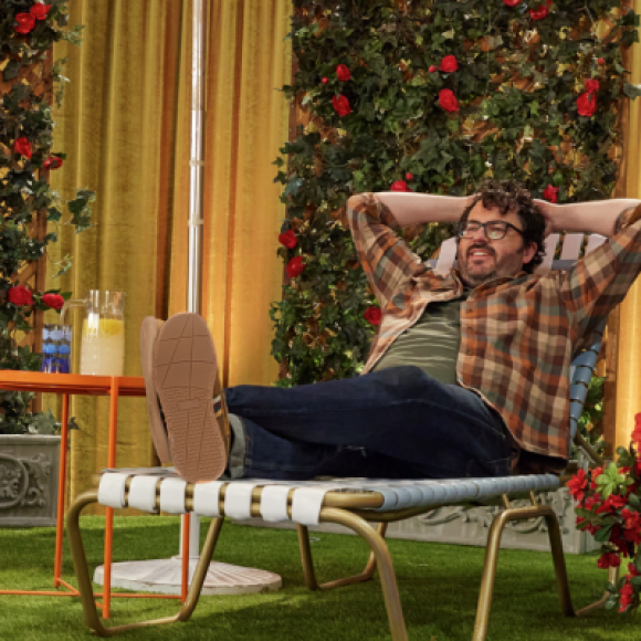 Man relaxing in lawn chair in flower garden