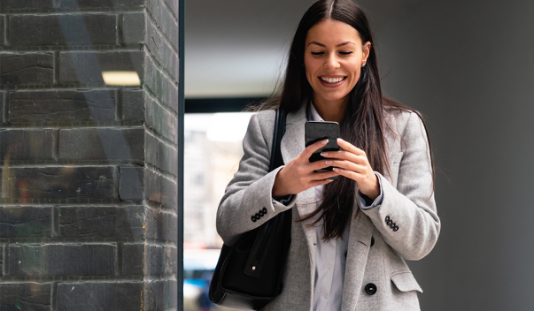 Woman smiling, typing on cell phone